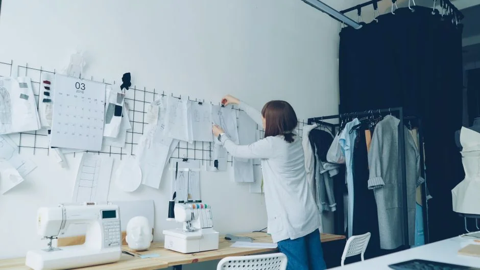 Lady wearing a floral outfit making an online purchase on her laptop using a credit card inside a room.